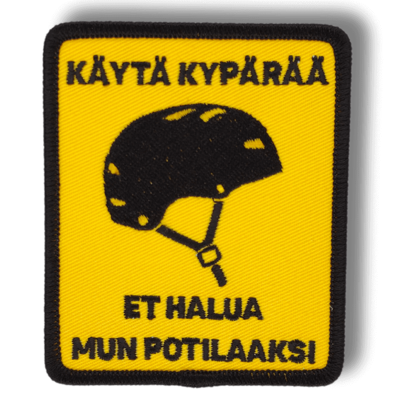 Brodeerattu haalarimerkki pyöräilykypärästä saumatulla reunalla, tekstillä: ''Käytä kypärää, et halua mun potilaaksi''
