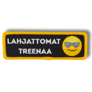 Brodeerattu haalarimerkki hymiöstä, jolla on aurinkolasit ja saumatulla reunalla, tekstillä: ''Lahjattomat treenaa''