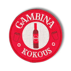Brodeerattu haalarimerkki Gambina pullosta saumatulla reunalla ja tekstillä: ''Gambina kokous''