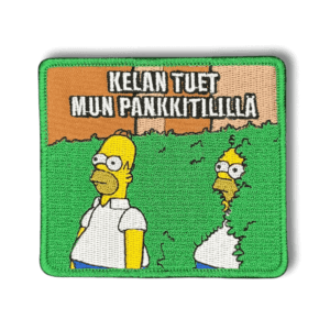 Brodeerattu haalarimerkki Simpsonit TV-sarjan Homer hahmosta saumatulla reunalla ja tekstillä: ''Kelan tuet mun pankkitilillä''