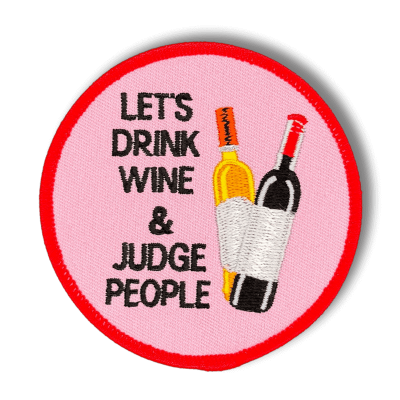 Brodeerattu haalarimerkki viinipulloista saumatulla reunalla, tekstillä: ''Let's drink wine and judge people''