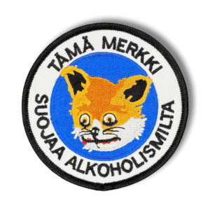 Brodeerattu haalarimerkki darraisesta kettu -meemistä saumatulla reunalla, tekstillä: ''Tämä merkki suojaa alkoholismilta''