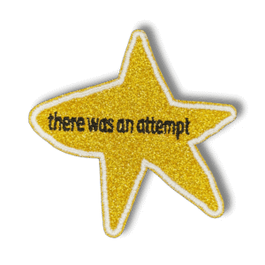 Brodeerattu haalarimerkki tähdestä glitterkankaalla, laserleikatulla reunalla ja tekstillä: ''There was an attempt''.