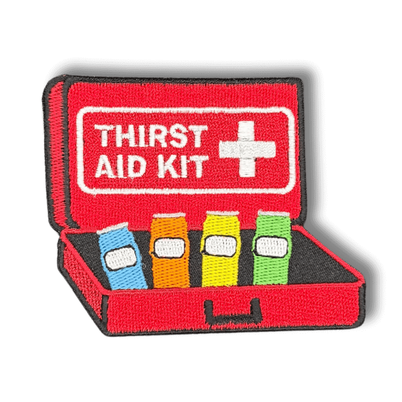 Brodeerattu haalarimerkki ensiapupakkauksesta saumatulla reunalla, tekstillä: ''Thirst Aid Kit''